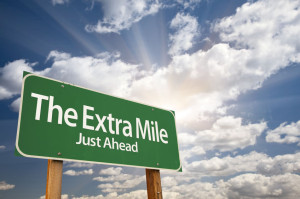 46565709 - the extra mile green road sign with dramatic clouds and sky.