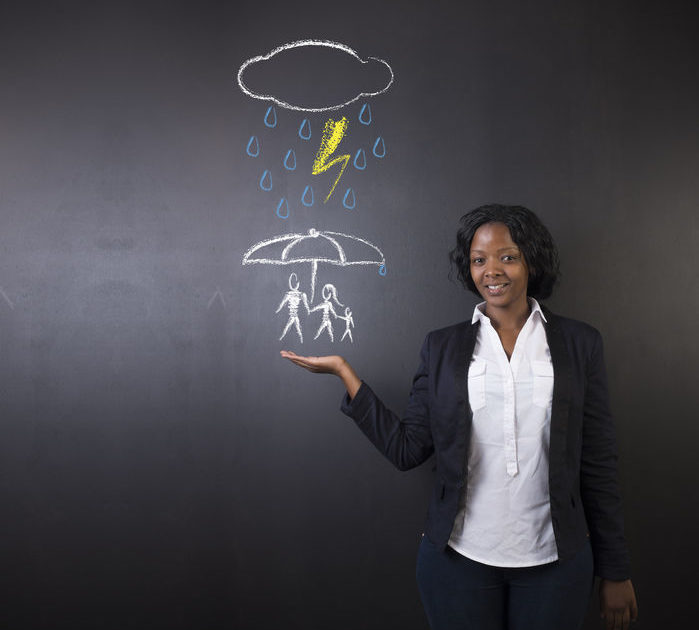 A women is giving a presentation regarding Rain with a protective umbrella over a family - Manning Insurance Services.