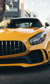 A yellow sports car is parked on the street - Manning Insurance Services' Car Insurance.